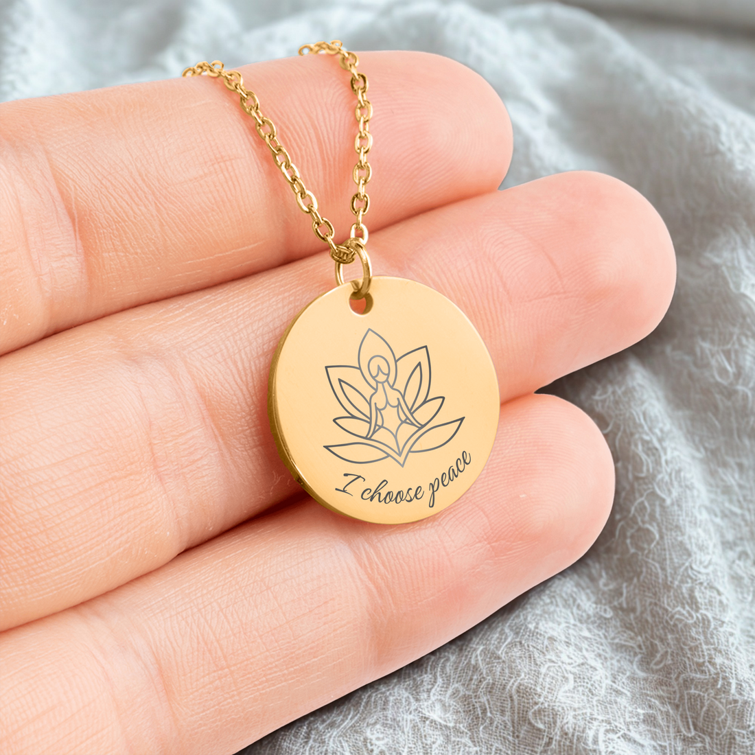 Hand houdt gouden affirmatieketting vast met gravure I choose peace – betekenisvol sieraad voor rust en zelfliefde