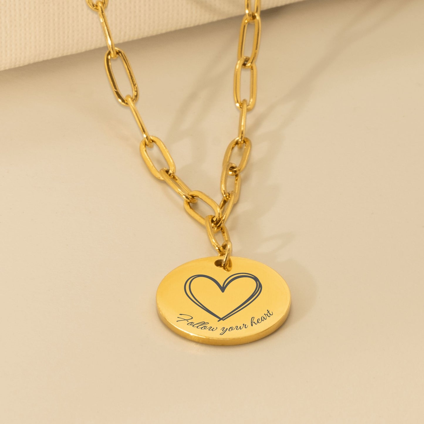 Close up van gouden affirmatieketting met gravure Follow your heart en hartje – betekenisvol sieraad voor liefde en vertrouwen