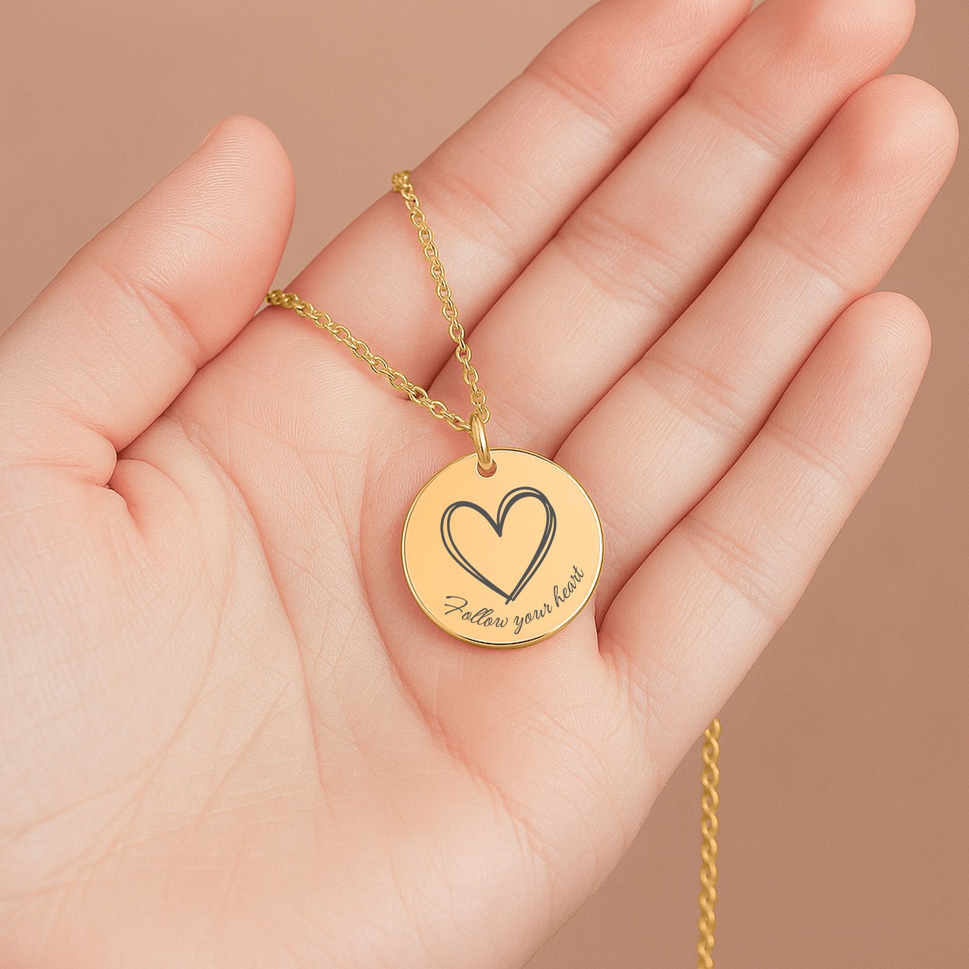 Het laten zien van een gouden affirmatieketting met gravure Follow your heart en hartje – betekenisvol sieraad voor liefde en vertrouwen